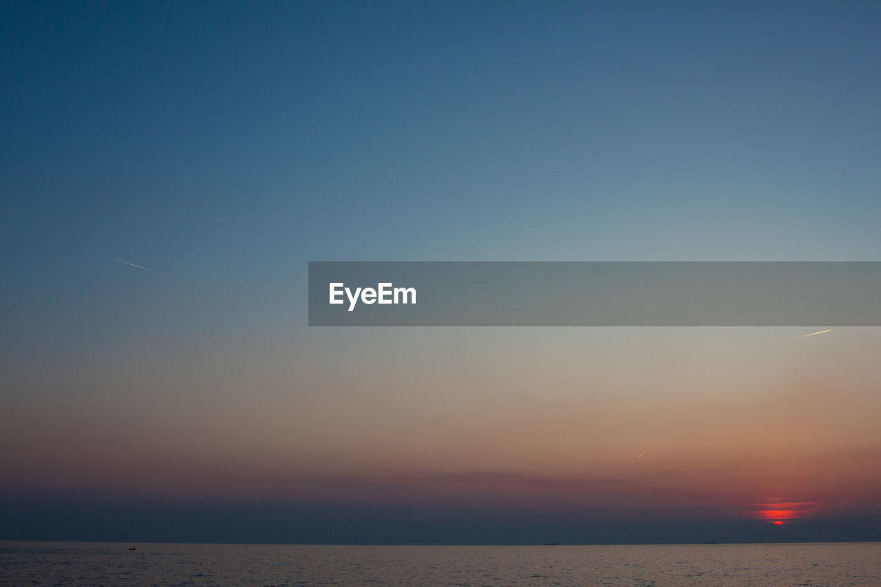 Scenic view of sea against clear sky during sunset