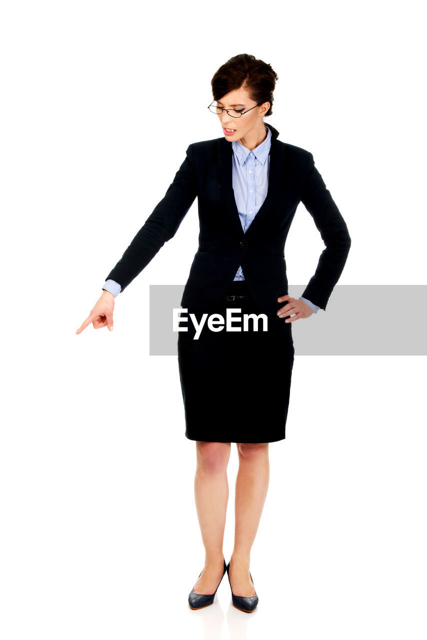 Full length of woman pointing while standing against white background