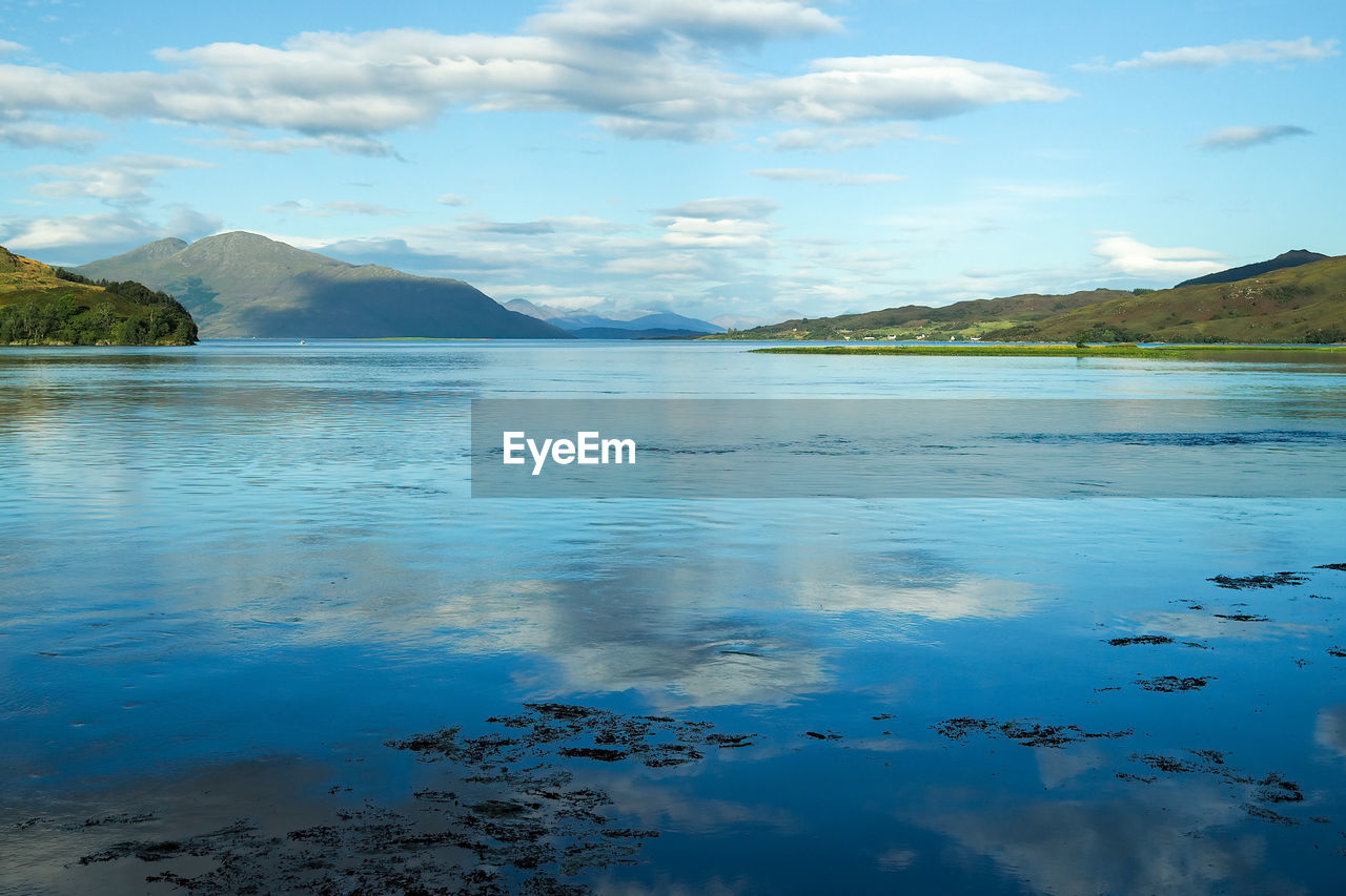 scenic view of lake against cloudy sky