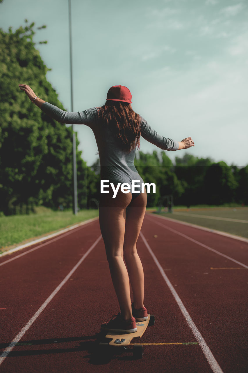 Woman skateboarding on running track