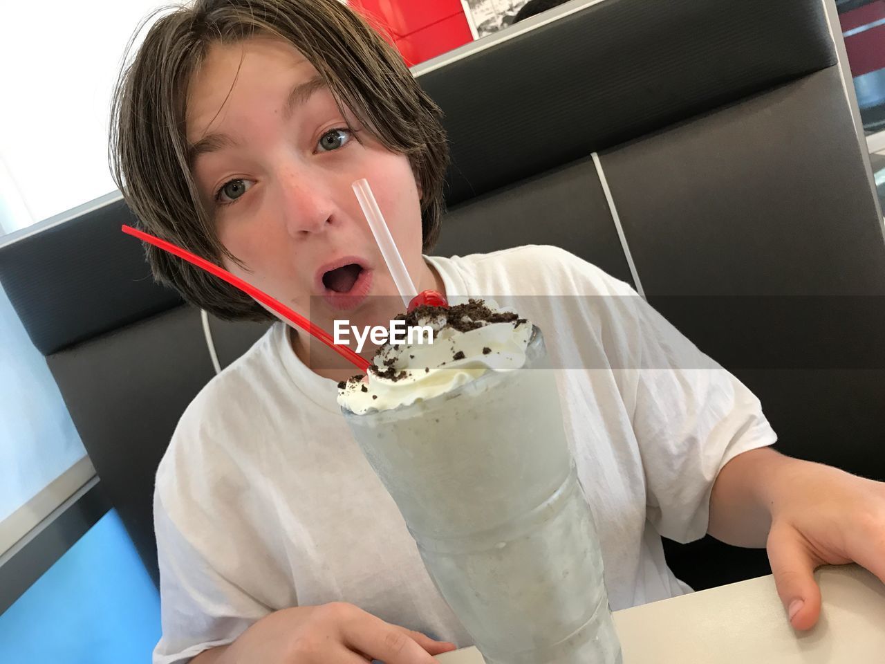 Portrait of surprised woman with ice cream in restaurant