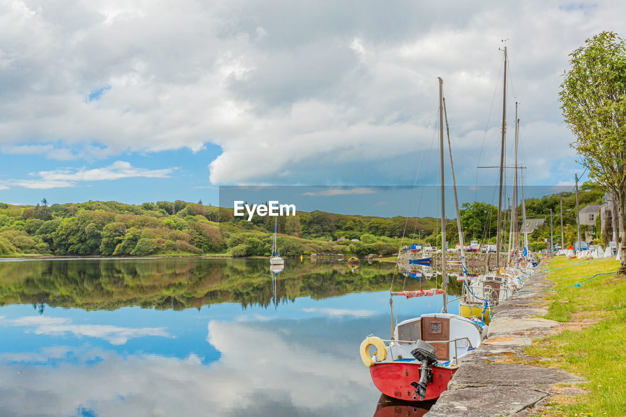 Scenic view of clifden bay at high tide against blue sky, sailing boats anchored in the harbour