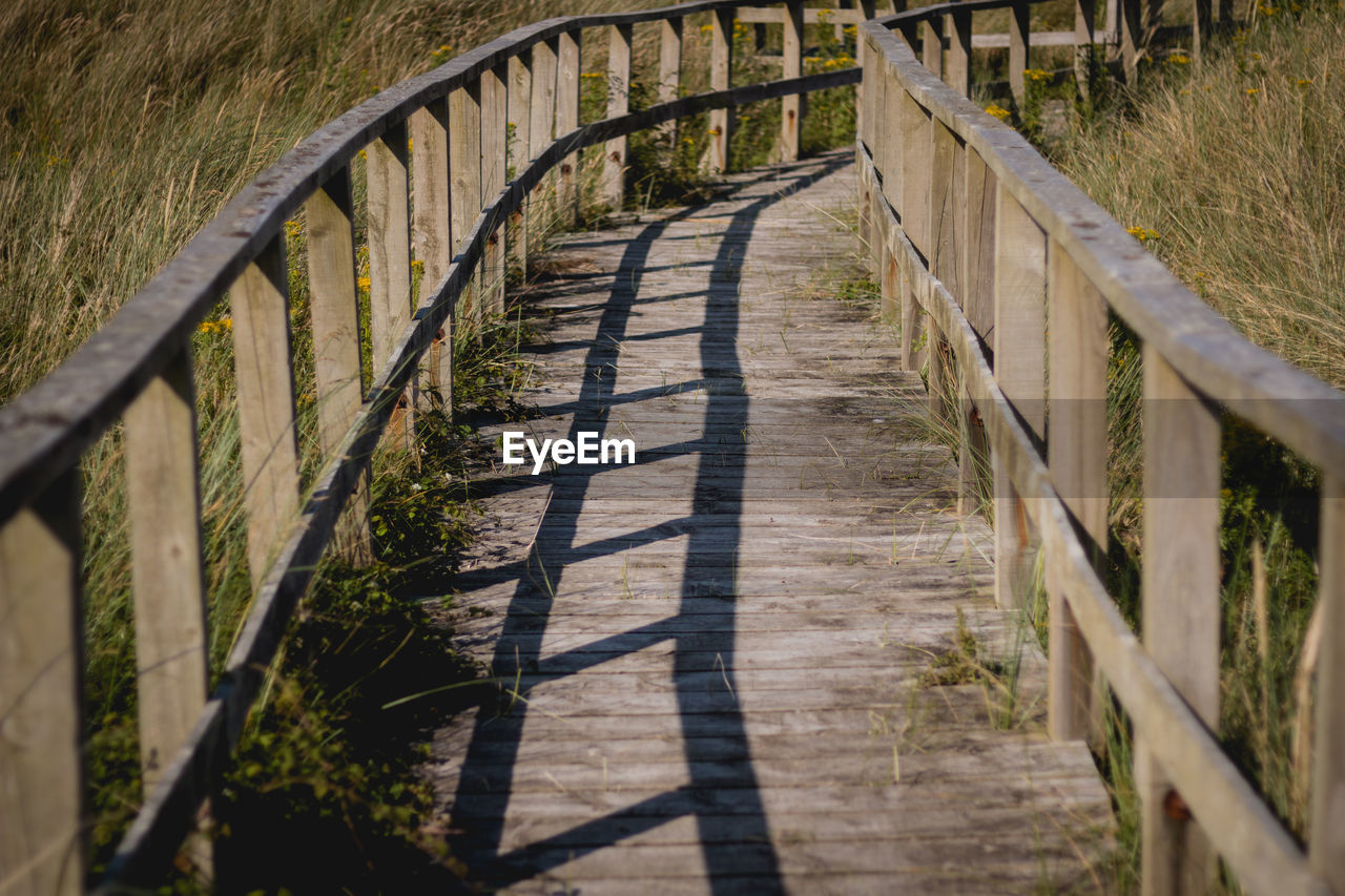 HIGH ANGLE VIEW OF FOOTPATH BY GRASS