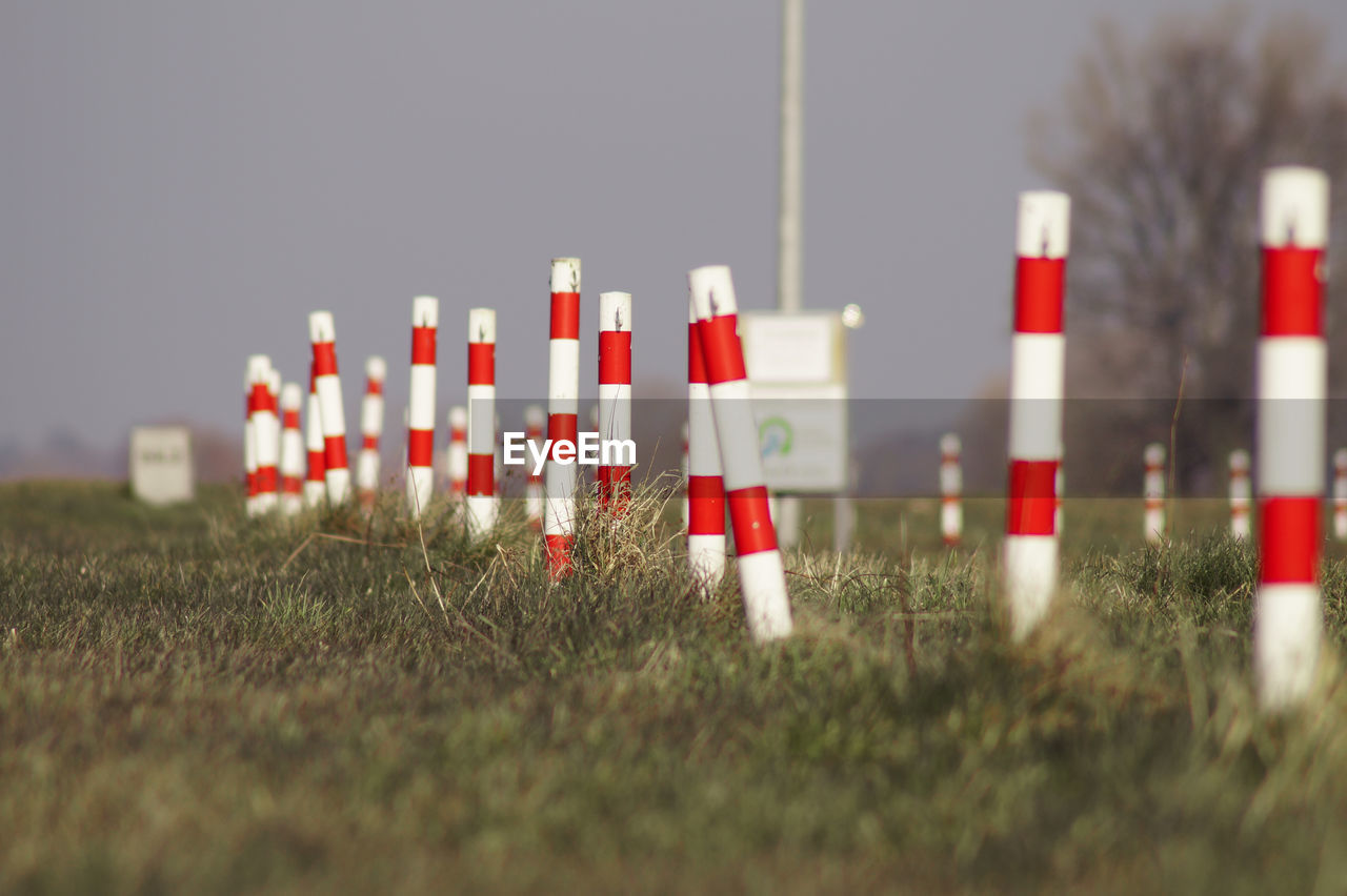 Surface level of poles on landscape against clear sky