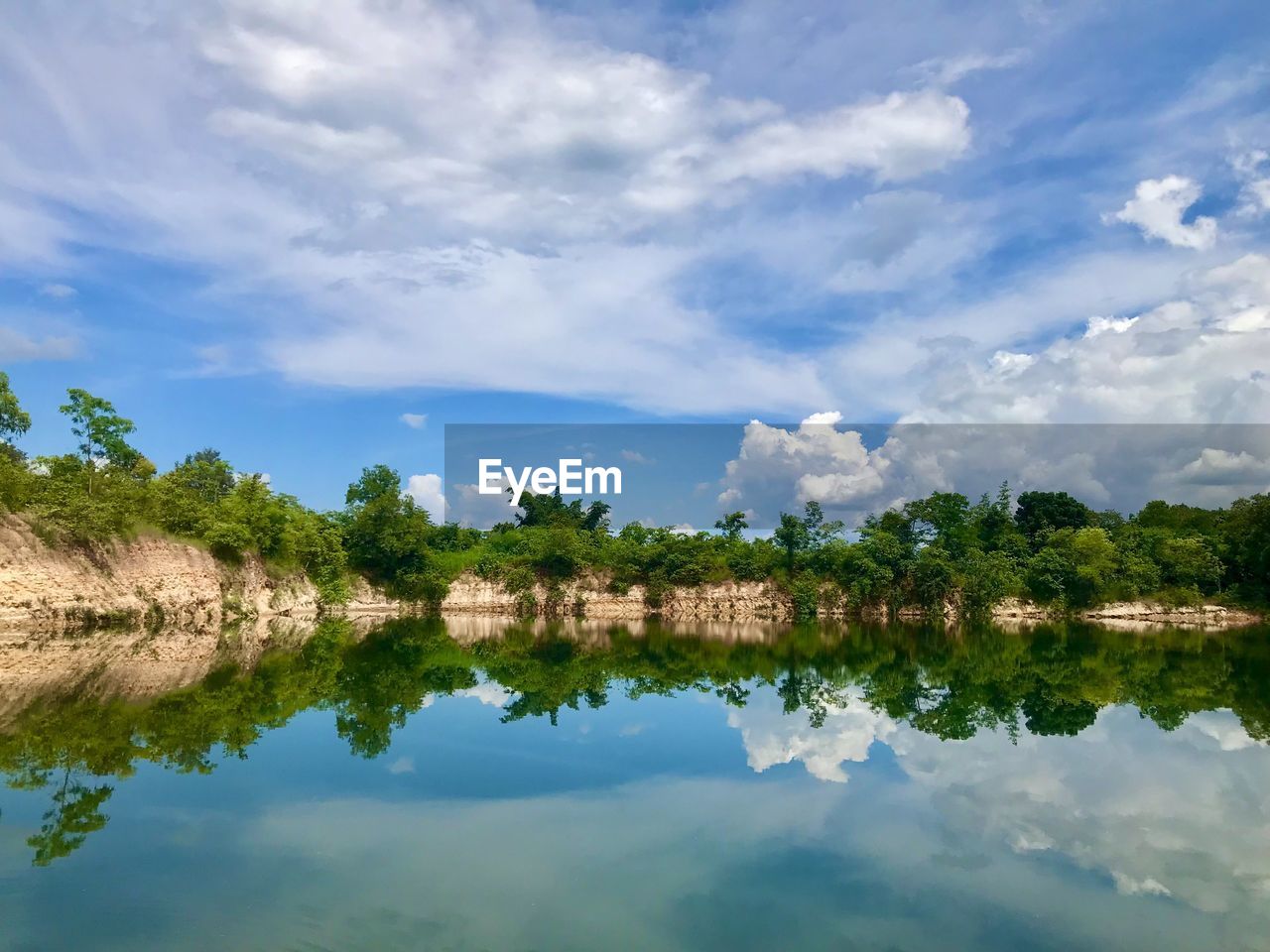 scenic view of lake by trees against sky