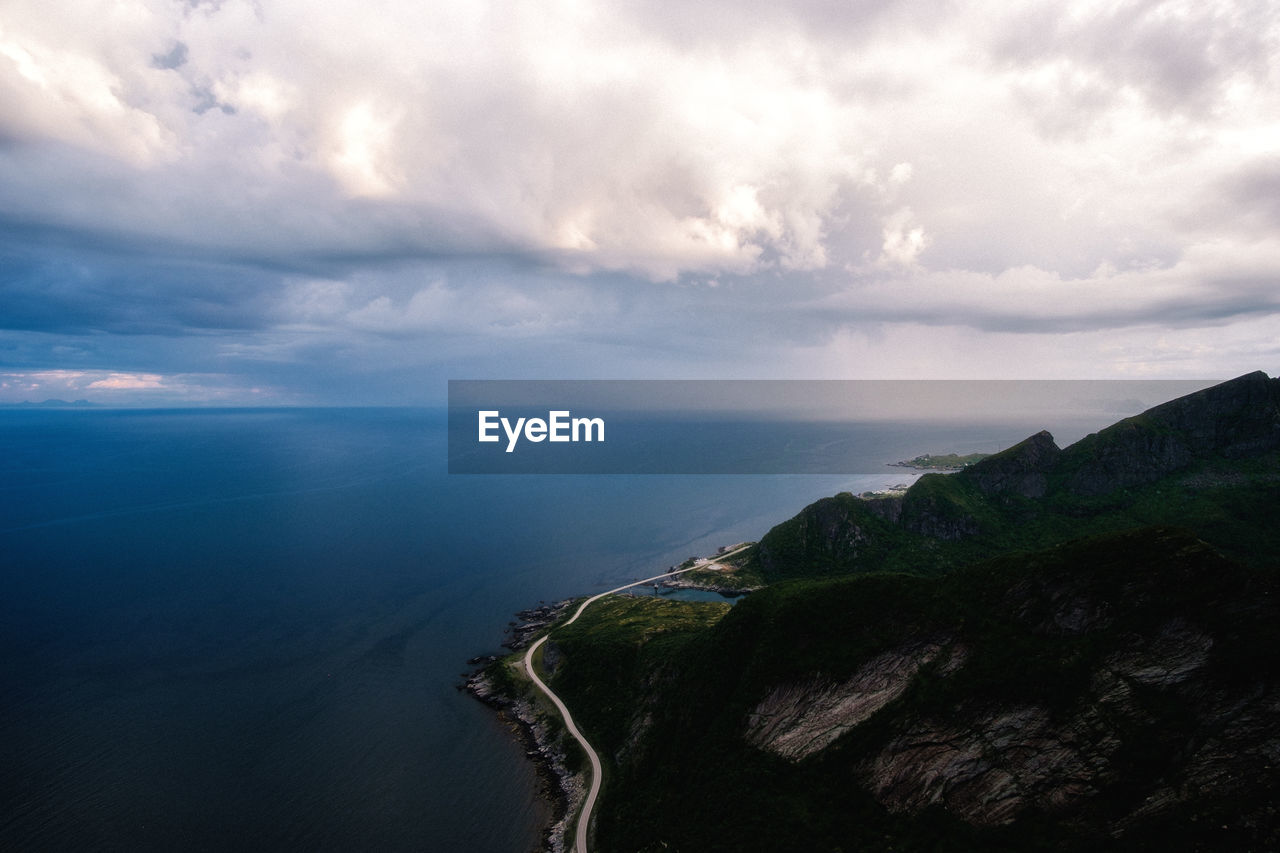 Scenic view of coastal road against dramatic sky