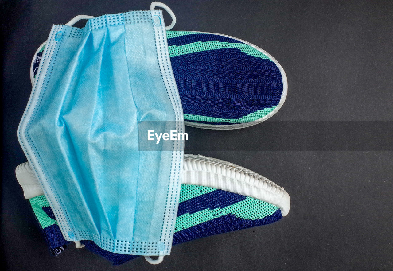 HIGH ANGLE VIEW OF SHOES ON BLUE TABLE