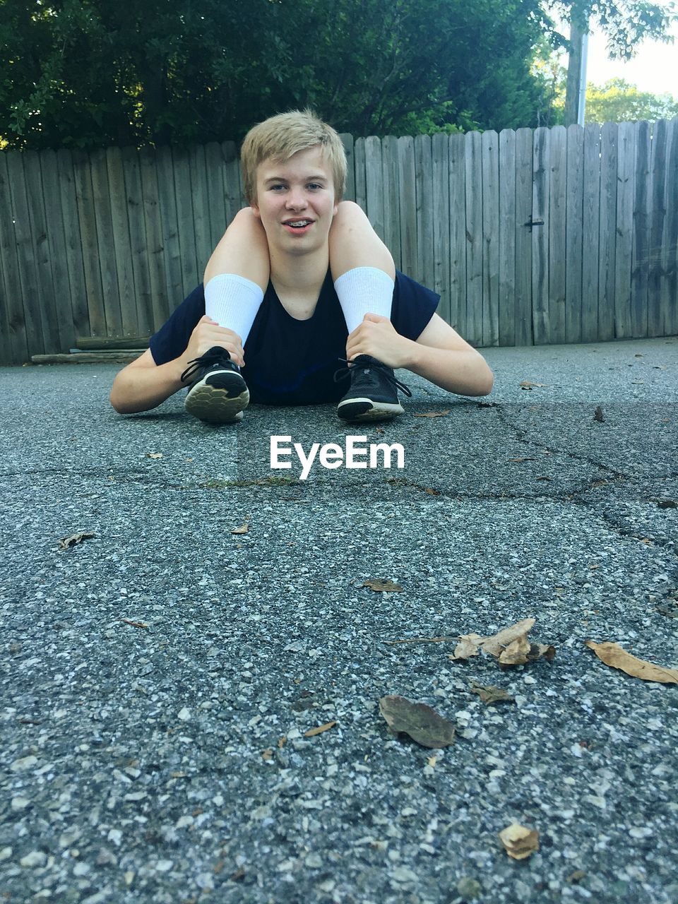 Portrait of man doing yoga on road