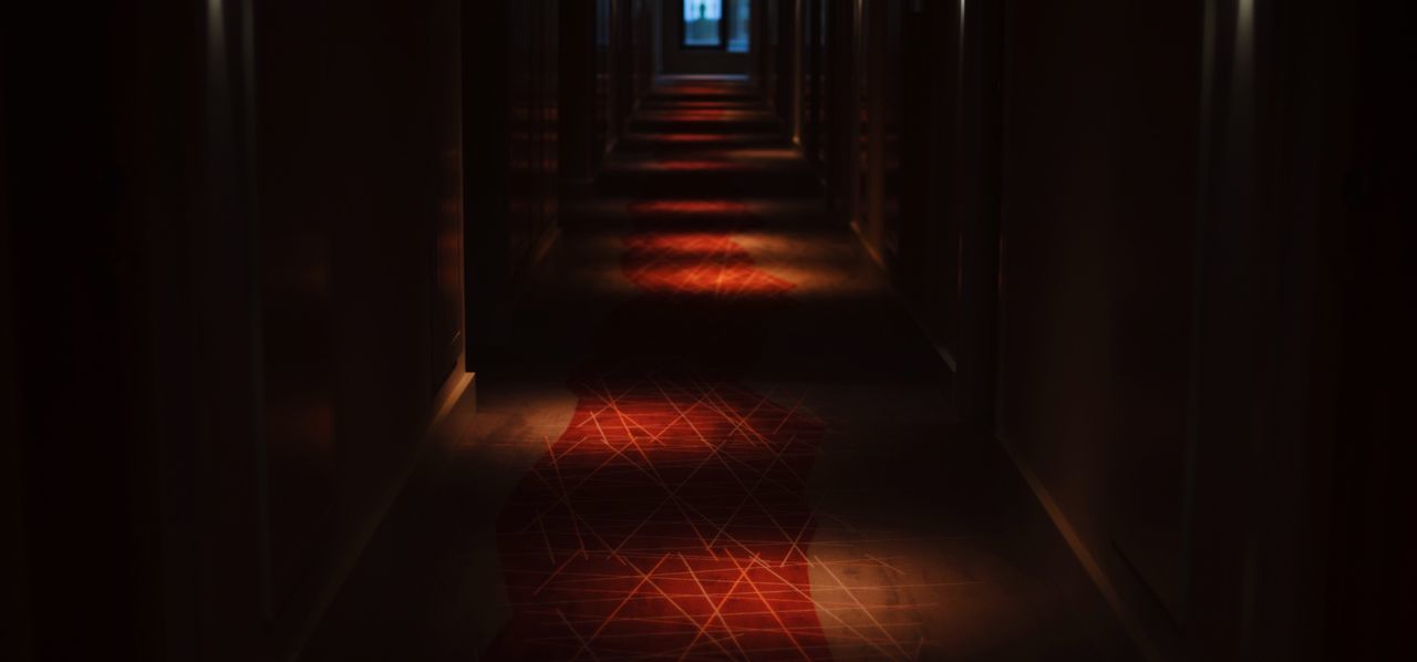 Empty corridor amidst walls at night