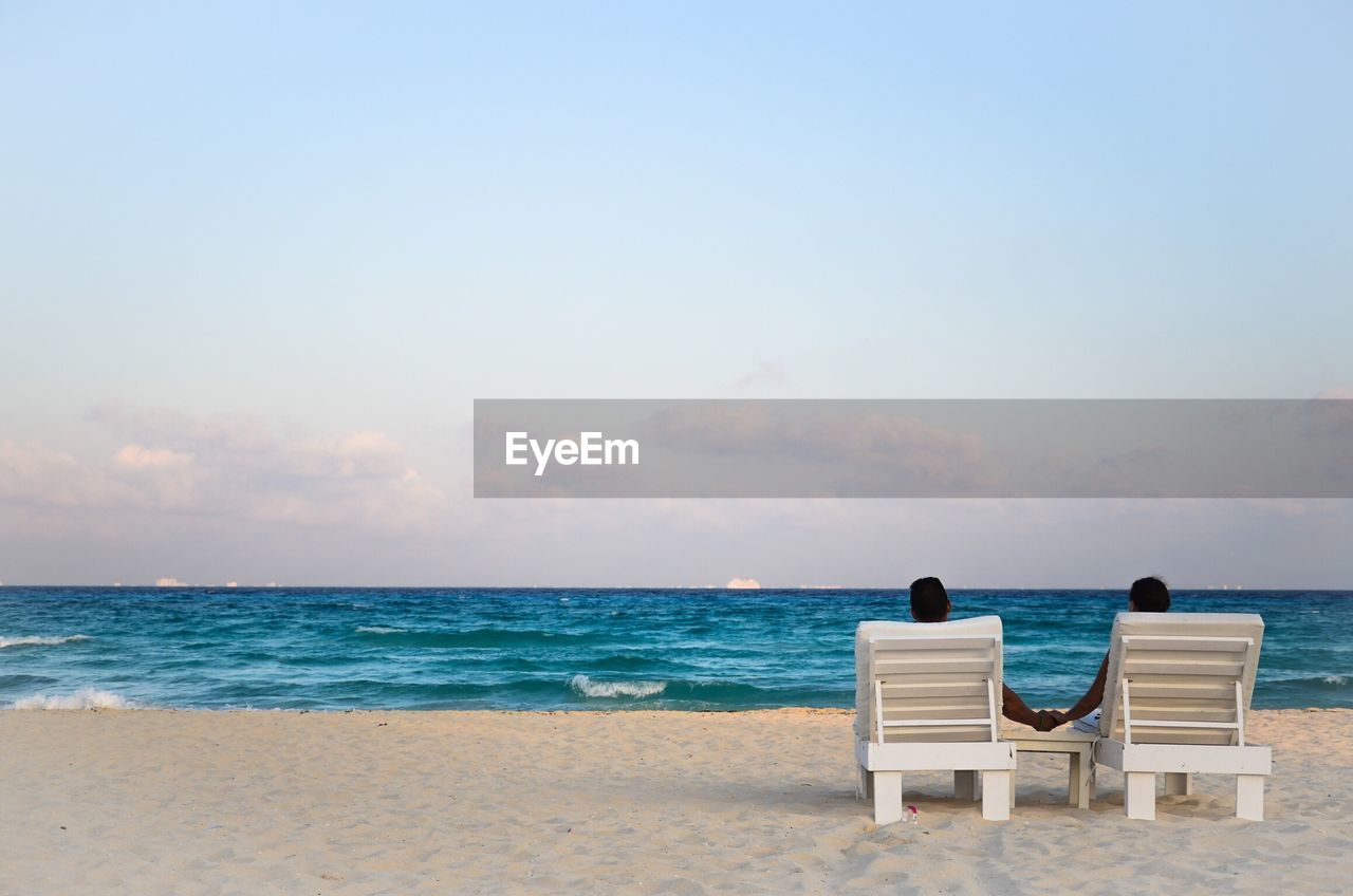 Couple on beach against sky