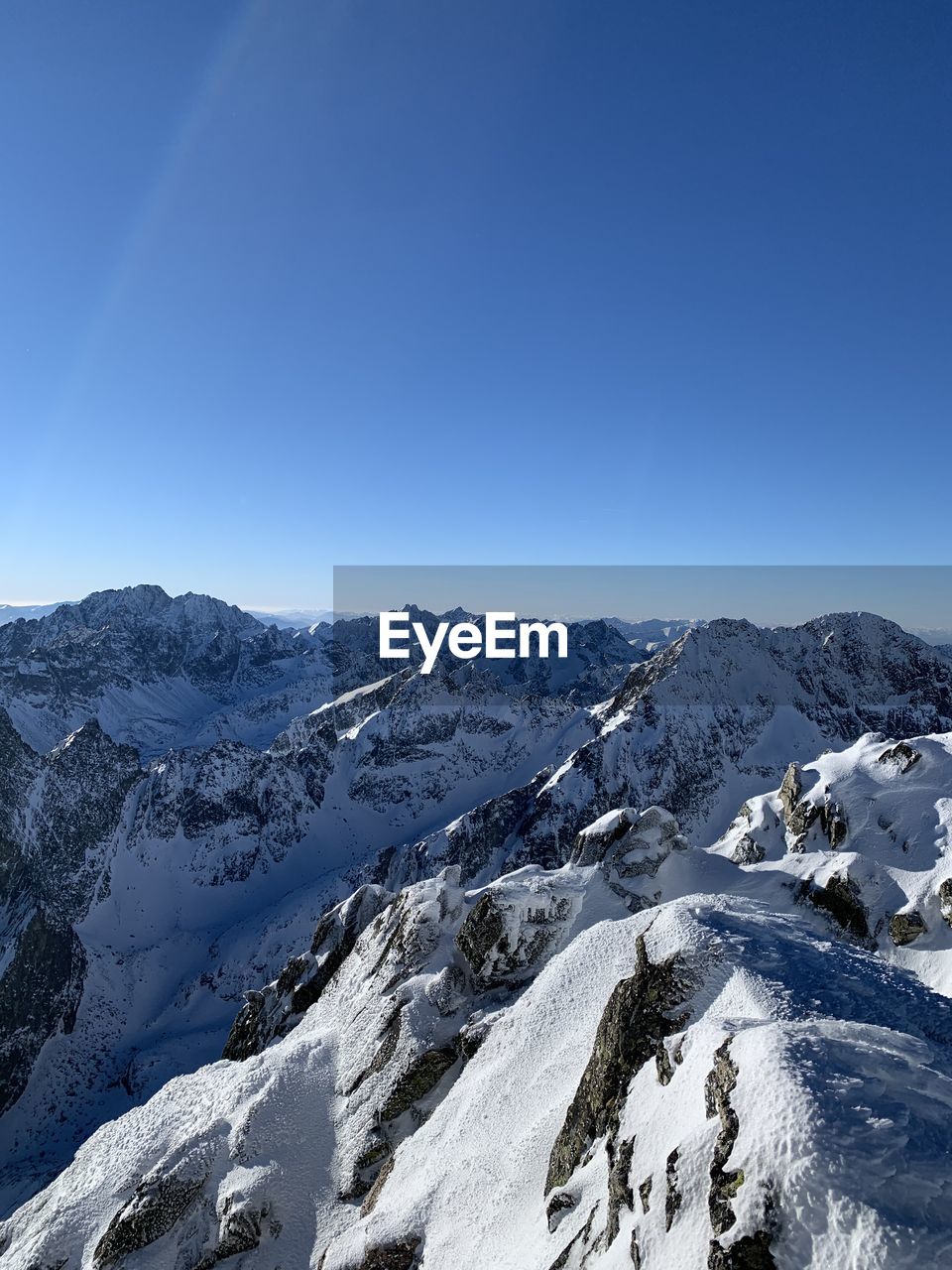 mountain, snow, cold temperature, mountain range, winter, blue, sky, nature, scenics - nature, beauty in nature, environment, mountaineering, no people, day, clear sky, landscape, outdoors, rock, ridge, summit, ice, tranquility, frozen, sunlight, snowcapped mountain, extreme terrain, tranquil scene, extreme sports, sports, mountain peak, non-urban scene, travel, adventure, low angle view, travel destinations, sunny