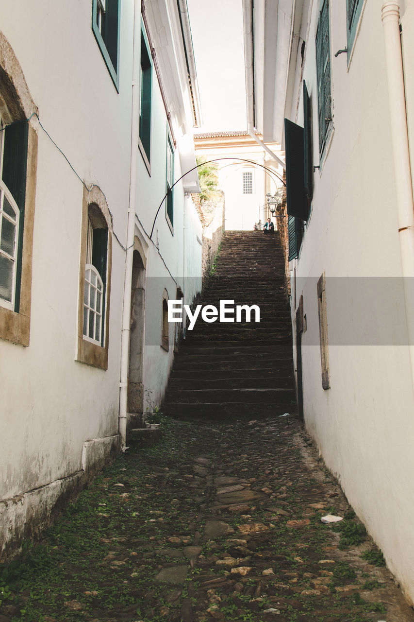 Footpath leading towards steps amidst buildings