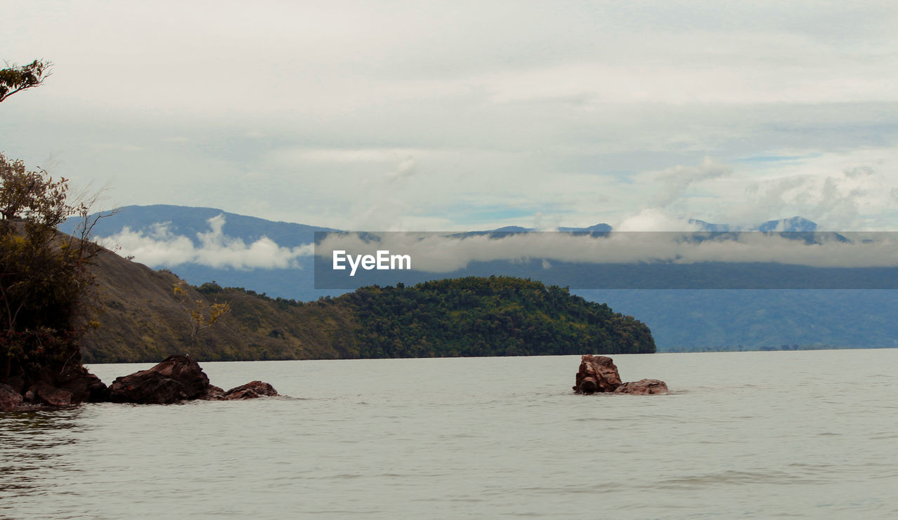 Scenic view of sea and mountains against sky