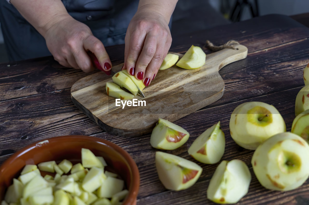 Women preparing delicious apple tart or pie .cutting apples or slicing