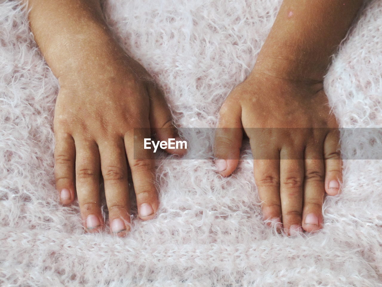 High angle view of person hands on rug 