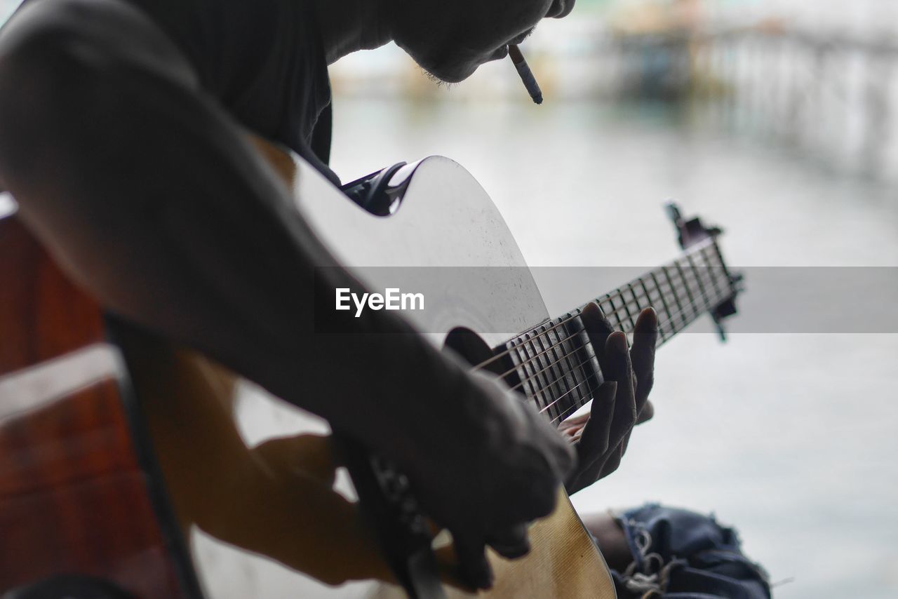 Close-up of man playing guitar