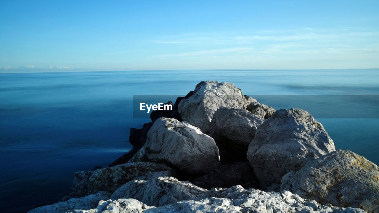 ROCKS ON BEACH AGAINST SKY