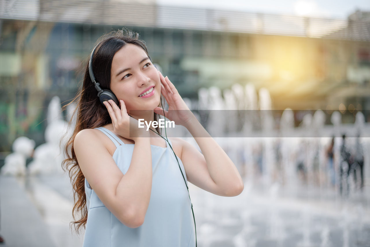 Smiling young woman listening to music