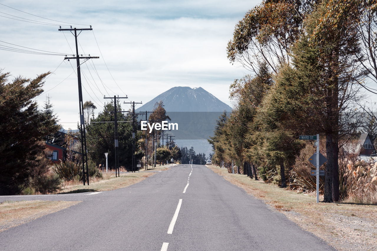 Road leading towards mountain against sky