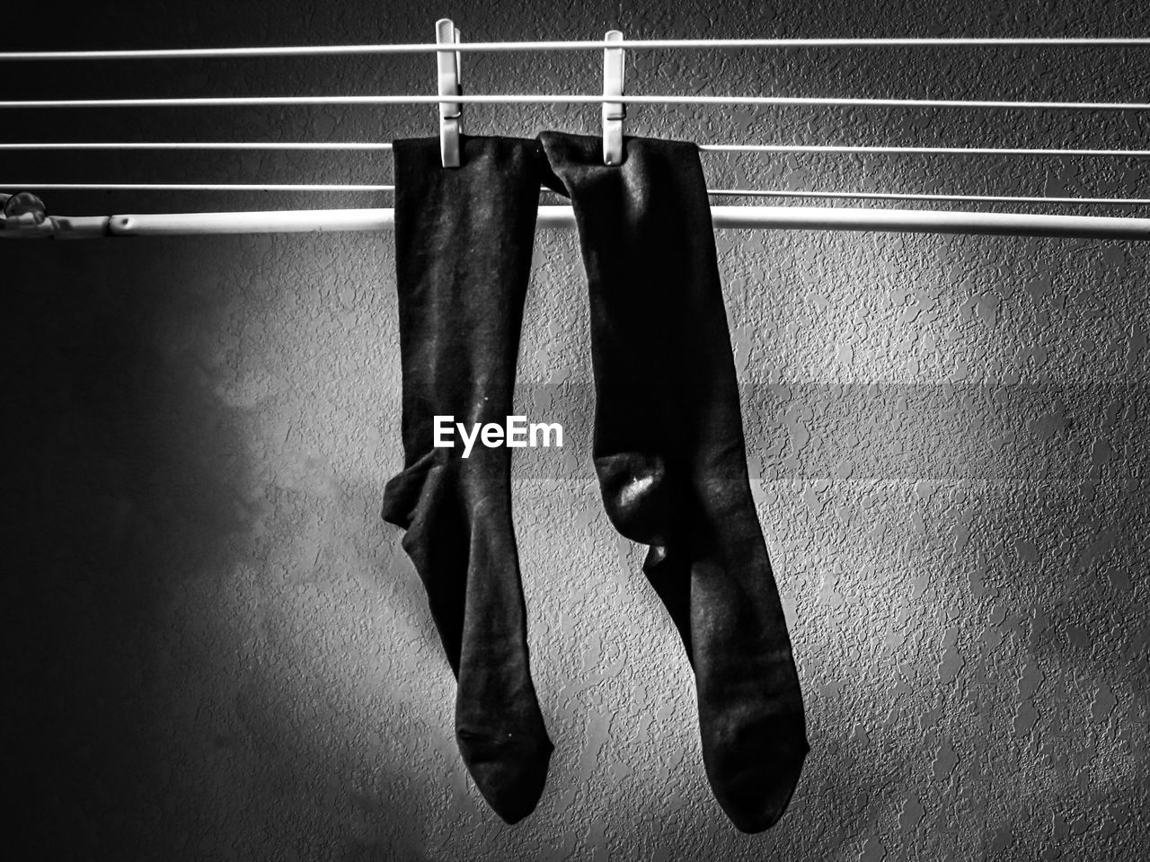 Socks drying on clothesline against wall