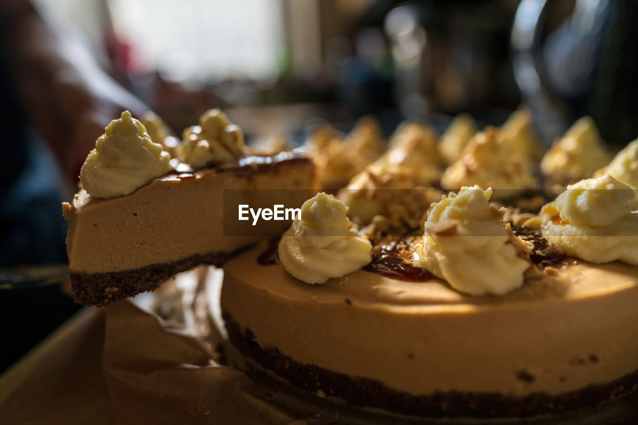 A knife cut piece of a sweet toffee caramel cake with nuts served as dessert, birthday celebration