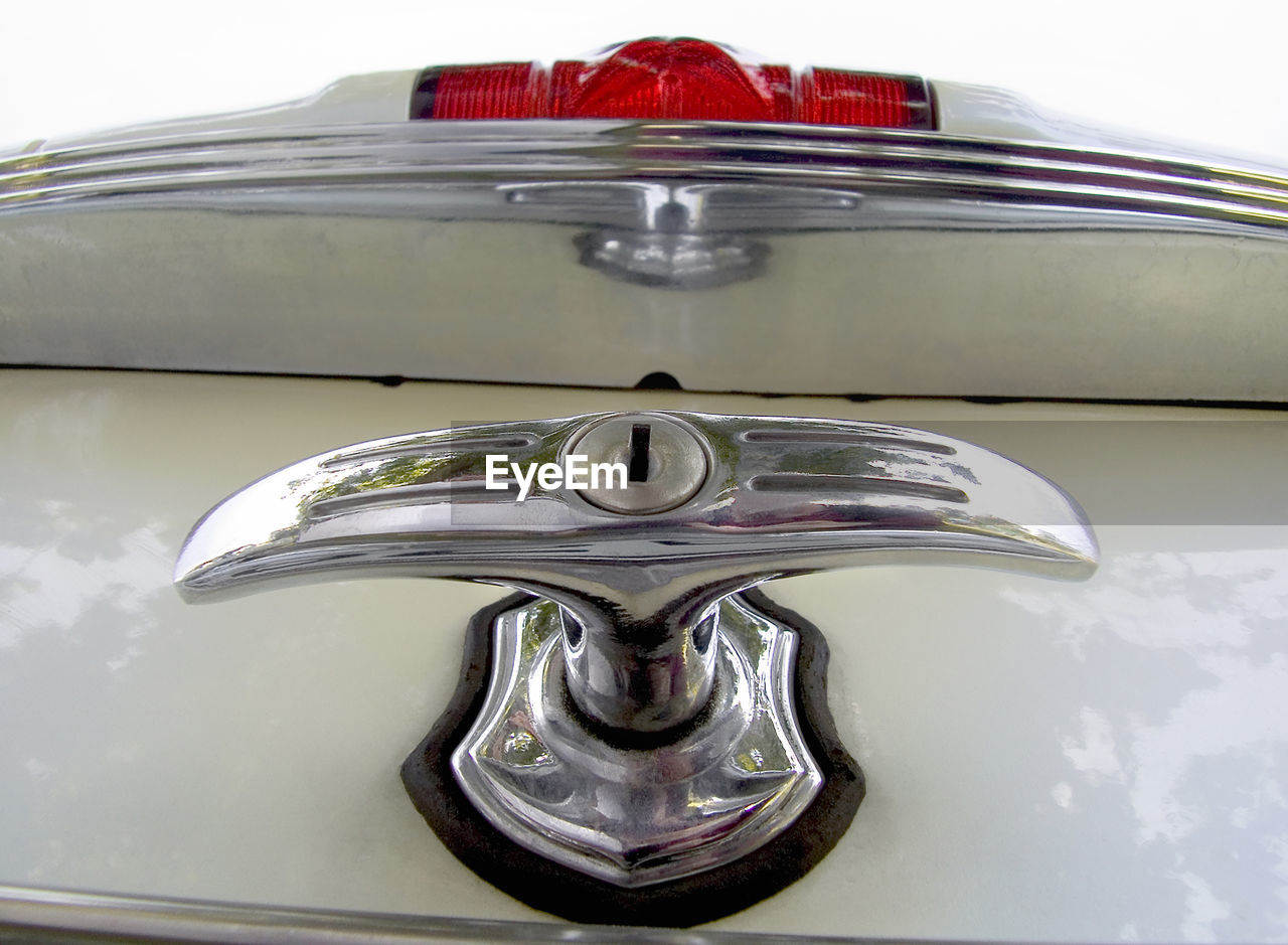 CLOSE-UP OF METALLIC OBJECT ON MIRROR