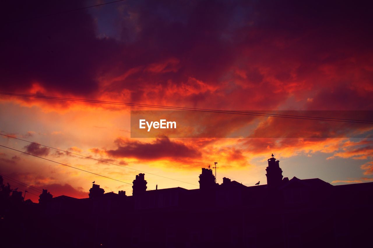 LOW ANGLE VIEW OF SILHOUETTE BUILDINGS AGAINST SKY