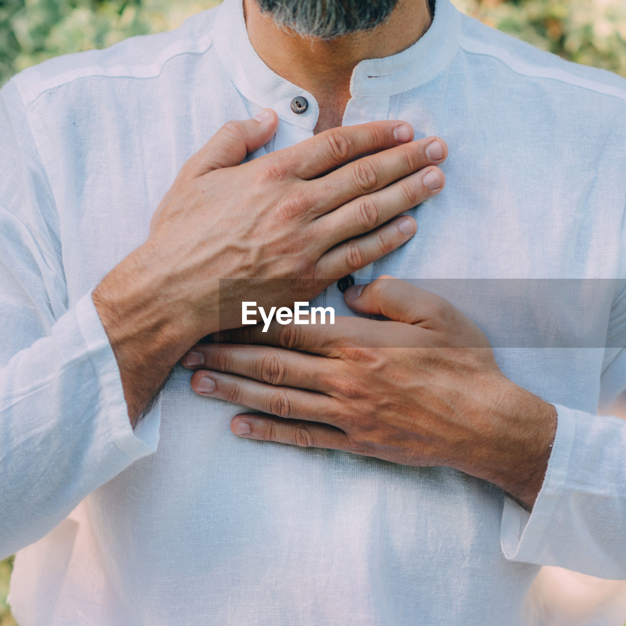 Reiki spiritual self-treatment healing session. man holding hands above the heart chakra.