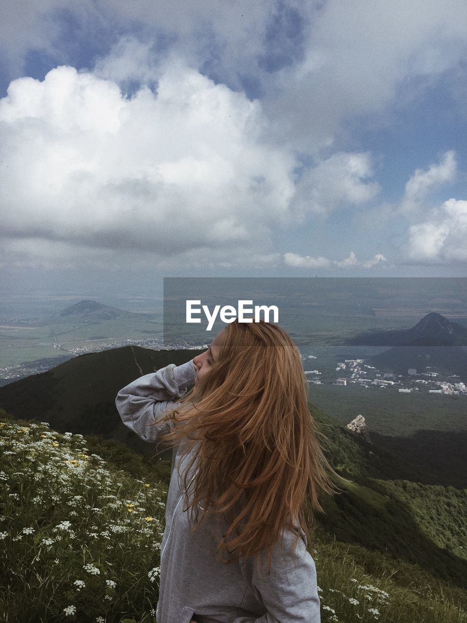 REAR VIEW OF WOMAN STANDING ON LANDSCAPE AGAINST MOUNTAIN