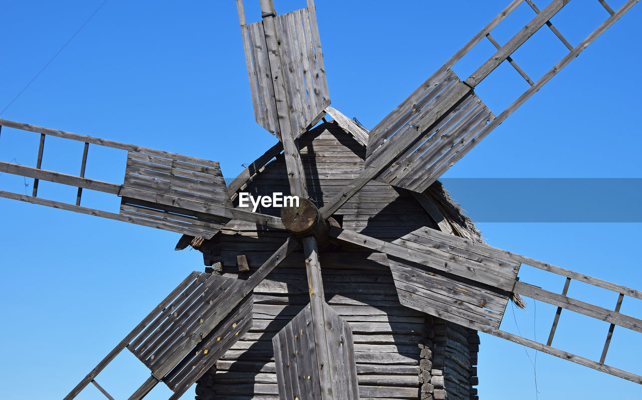 High section of windmill against clear blue sky