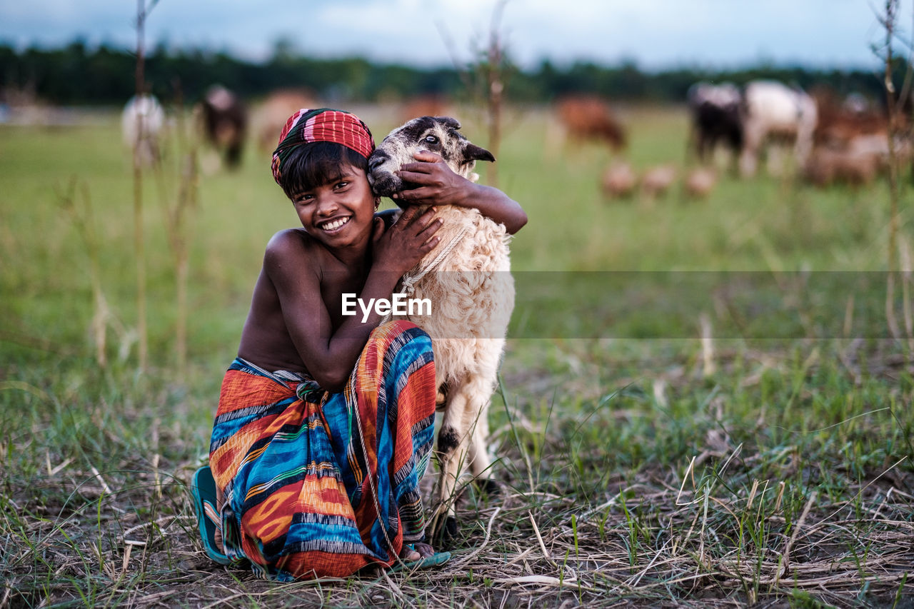 WOMEN SITTING ON FIELD BY LAND