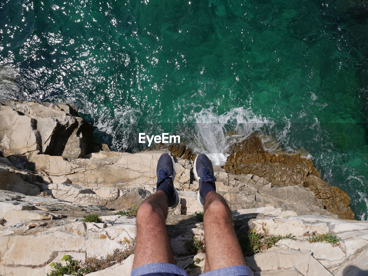 Low section of man on rock by sea