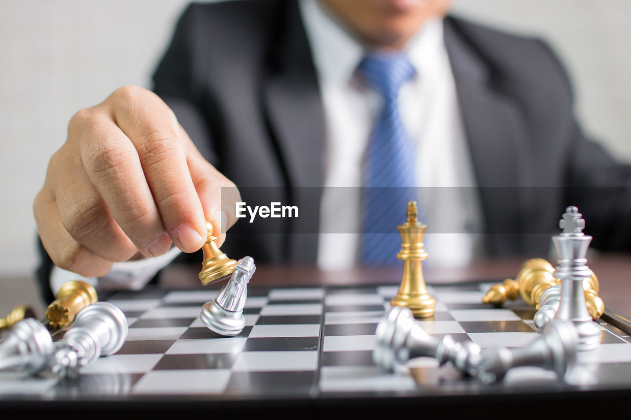 Close-up of businessman playing chess