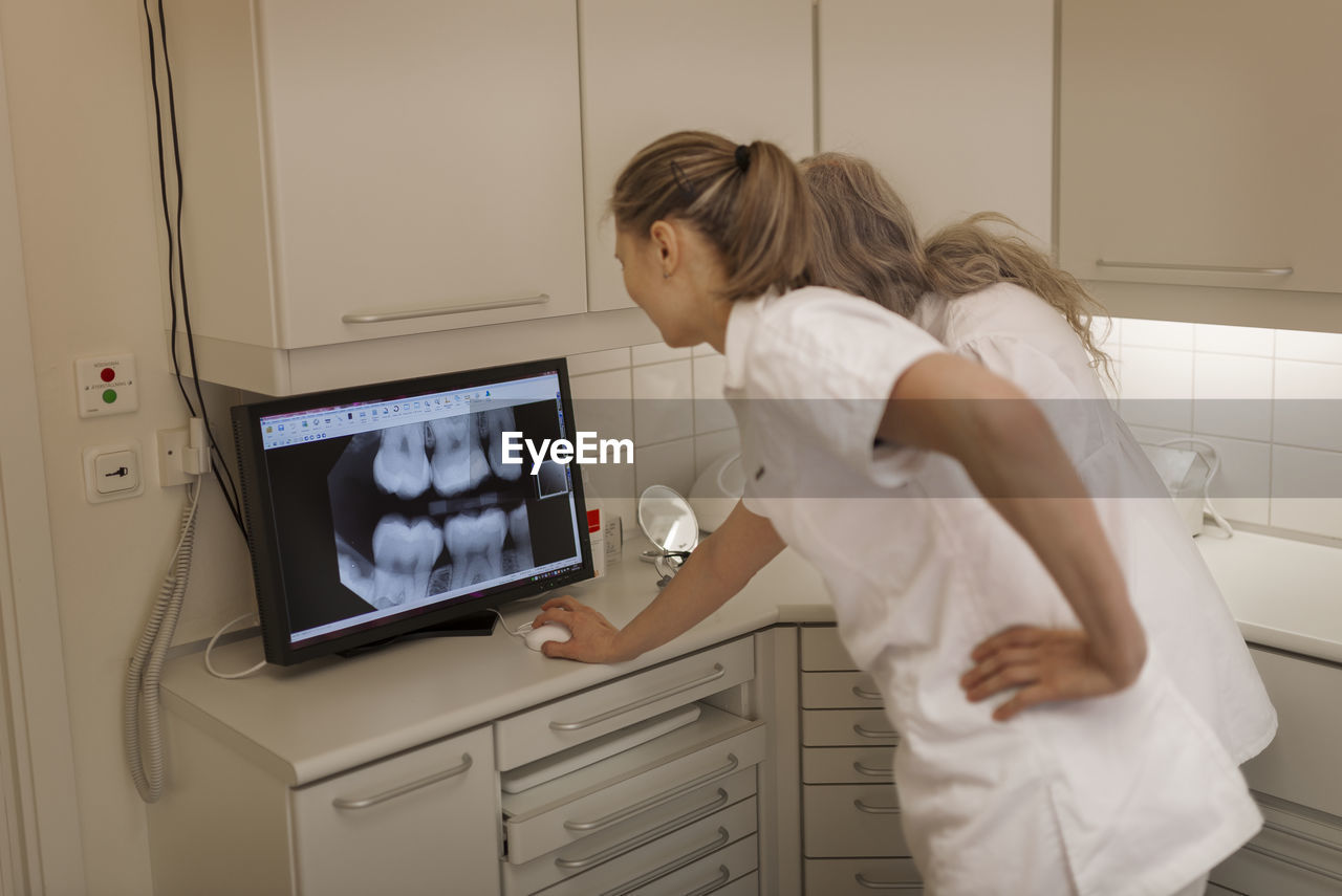 Dentist looking at x-ray on screen