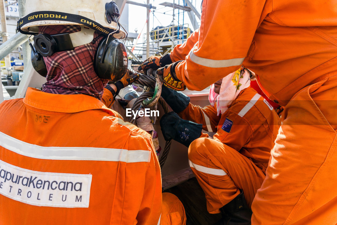 GROUP OF PEOPLE WORKING ON ORANGE UMBRELLA