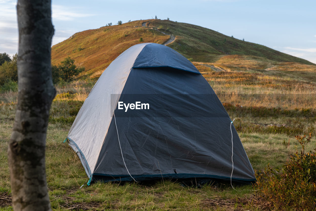 tent, camping, nature, landscape, adventure, land, mountain, scenics - nature, environment, plant, travel, travel destinations, sky, trip, vacation, beauty in nature, grass, leisure activity, tree, holiday, hiking, non-urban scene, hiking equipment, tranquility, remote, activity, tranquil scene, outdoors, day, wilderness, forest, relaxation, tourism, exploration, recreation, mountain range, summer
