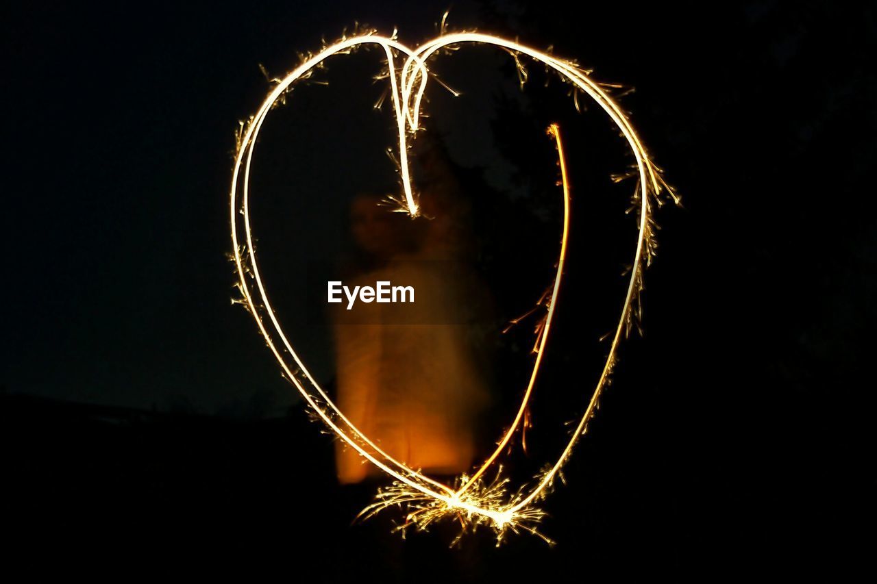 Close-up of heart shape by light painting at night