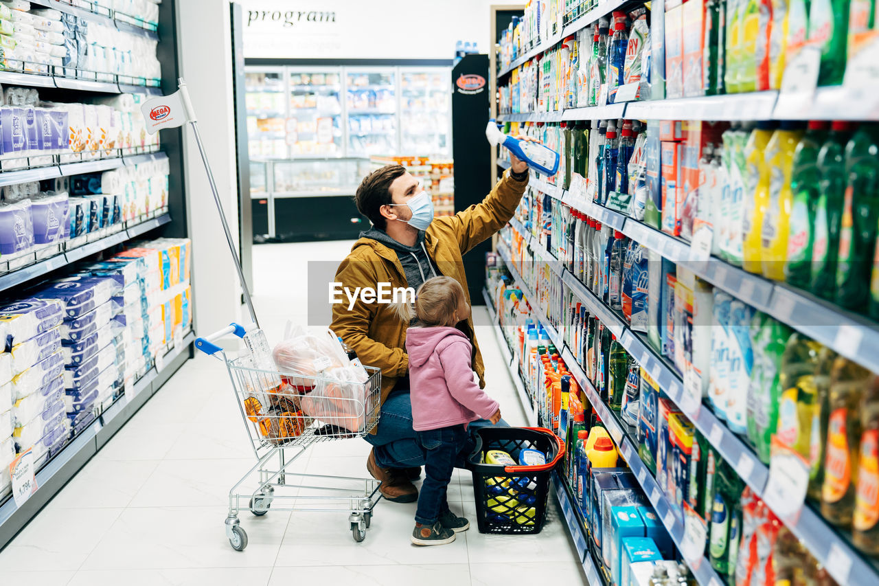 REAR VIEW OF MOTHER AND DAUGHTER ON STORE