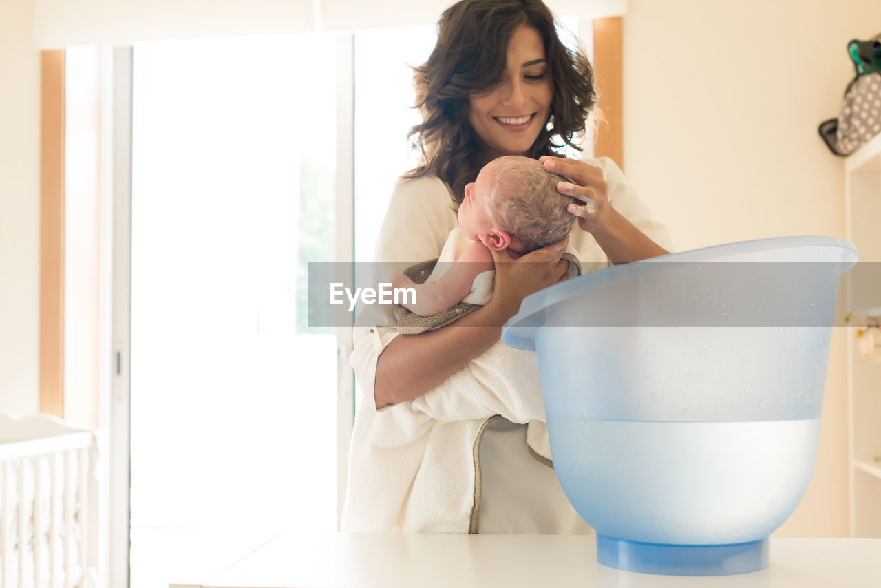 Mother bathing son in bathtub at bathroom