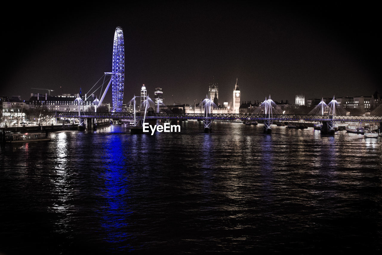 Golden jubilee bridge over thames river with illuminated london eye