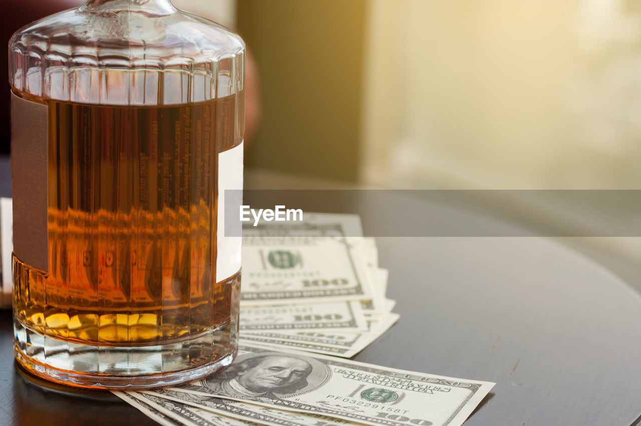 CLOSE-UP OF DRINK ON GLASS TABLE