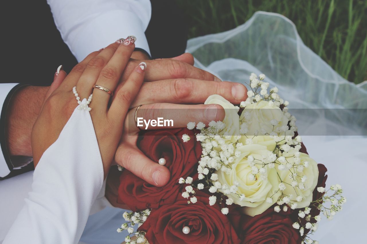 Mid section of a couple holding bouquet