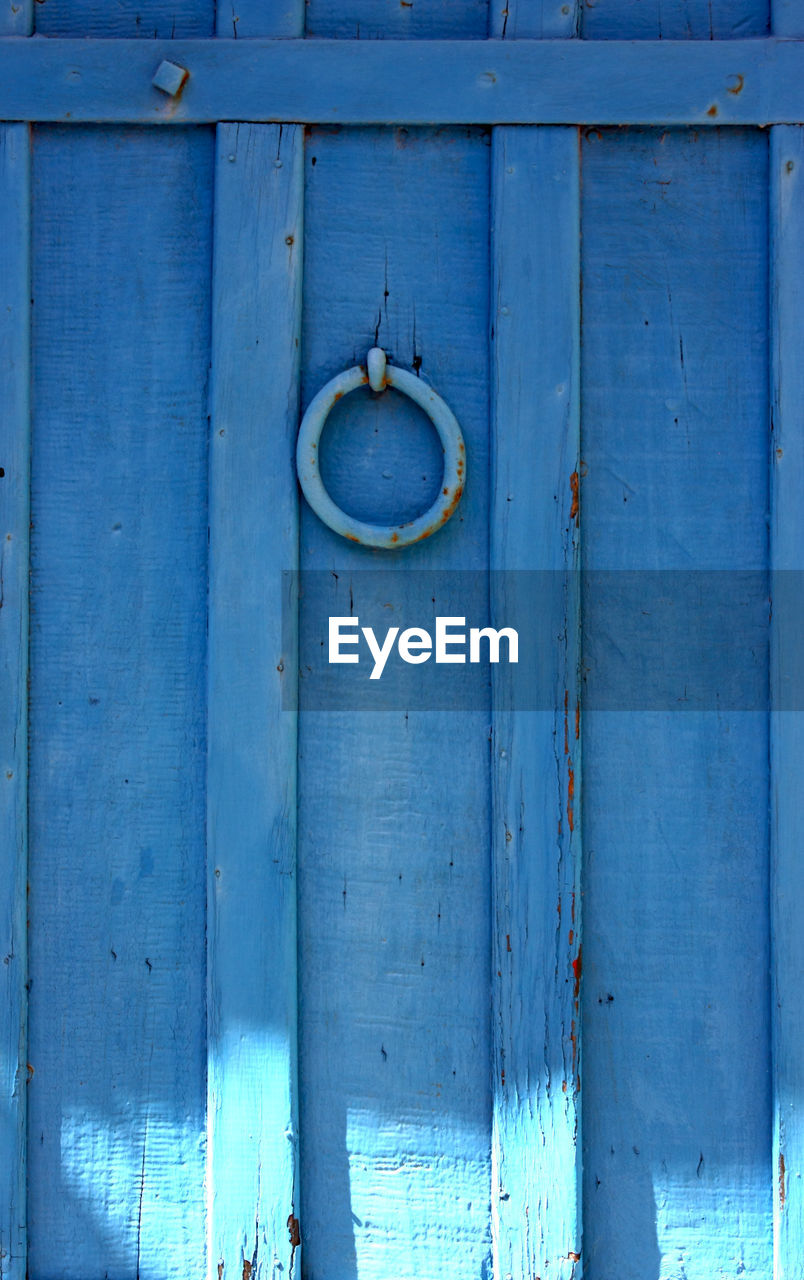 Low angle view of door knocker on blue door