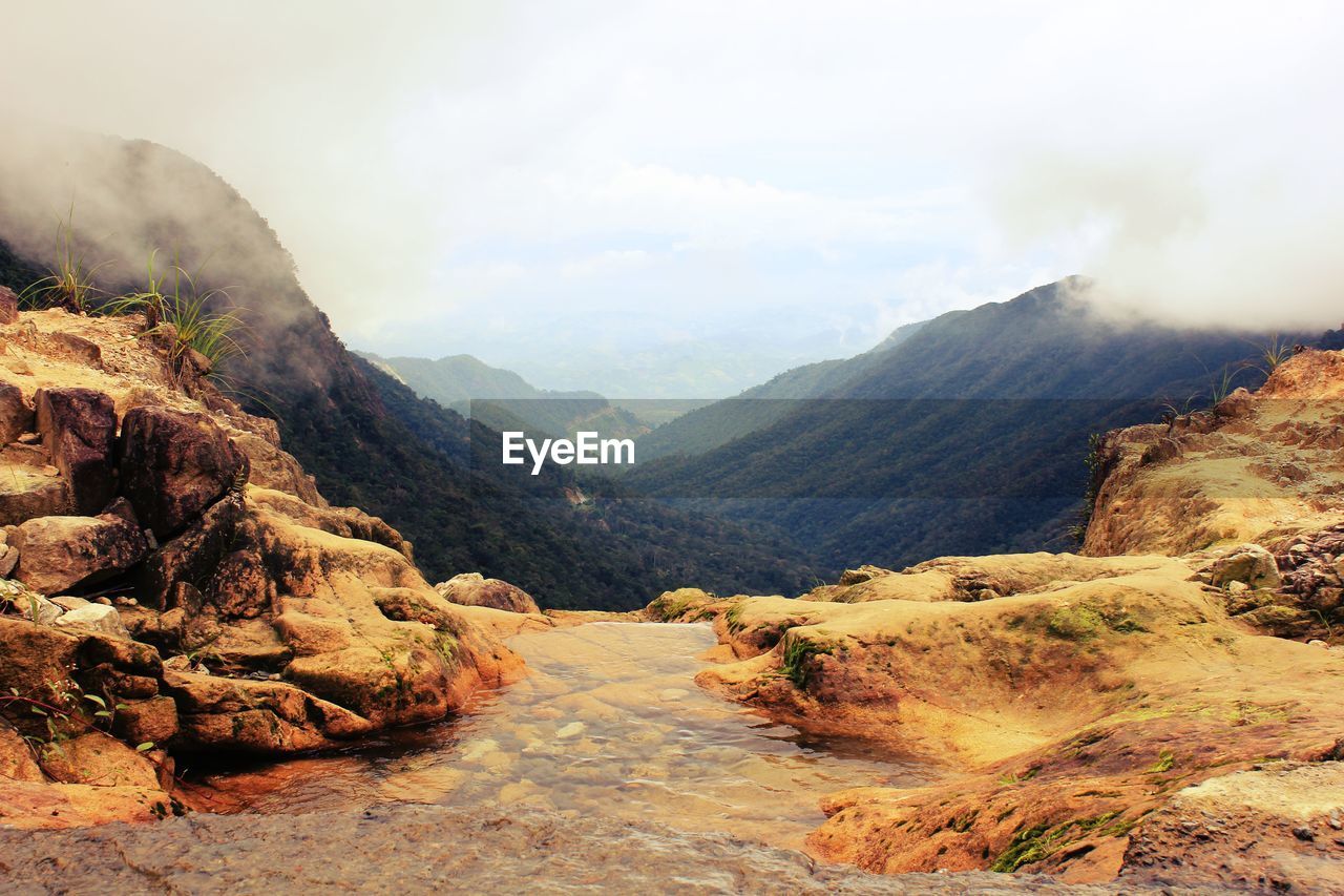 Scenic view of mountains against cloudy sky