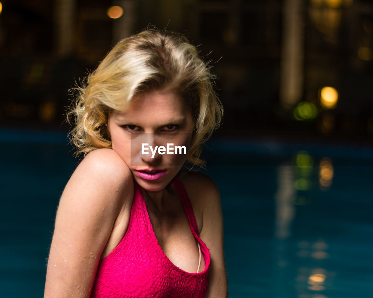 PORTRAIT OF BEAUTIFUL YOUNG WOMAN SWIMMING IN POOL