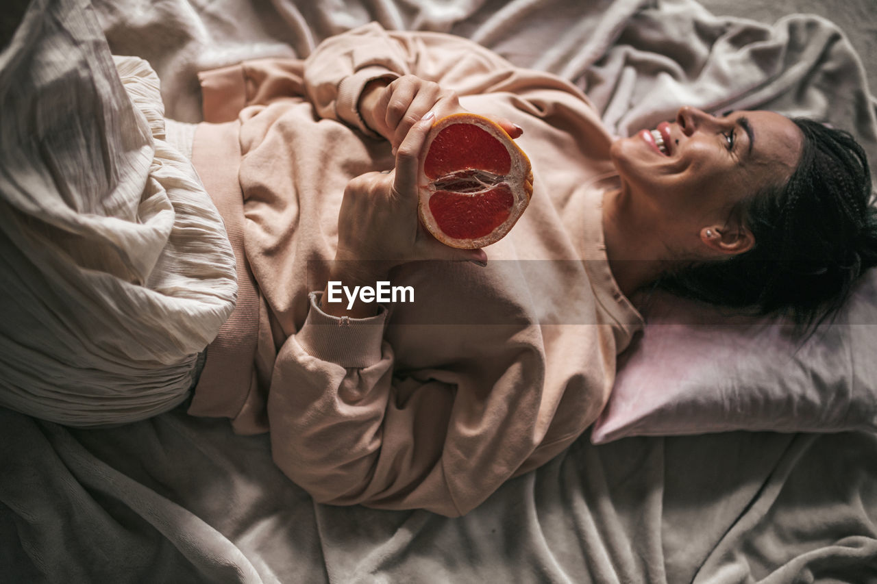 High angle view of woman lying on bed at home