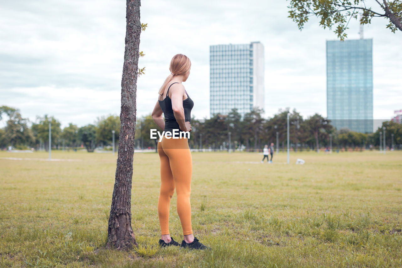 Fit and muscular blonde woman standing in the park