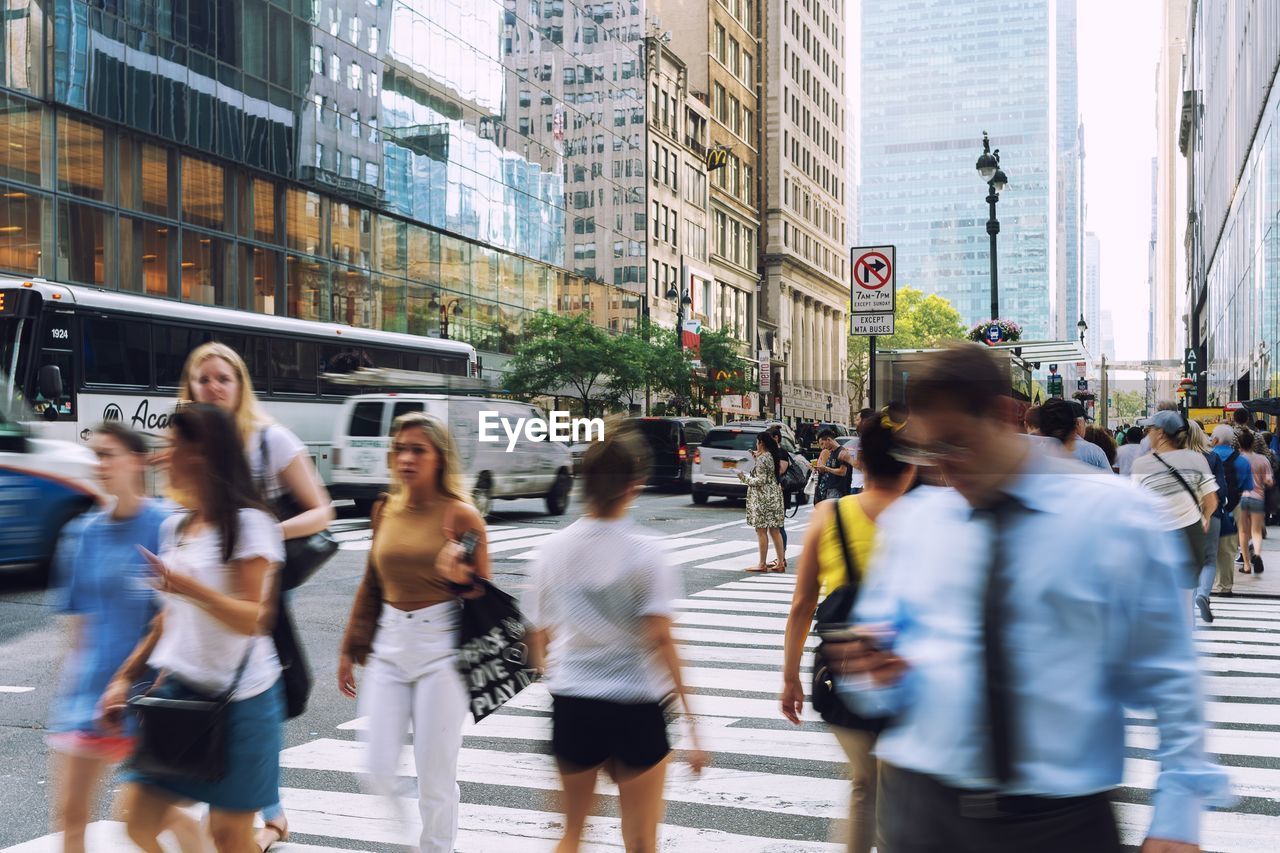 Blurred motion of people crossing road in city