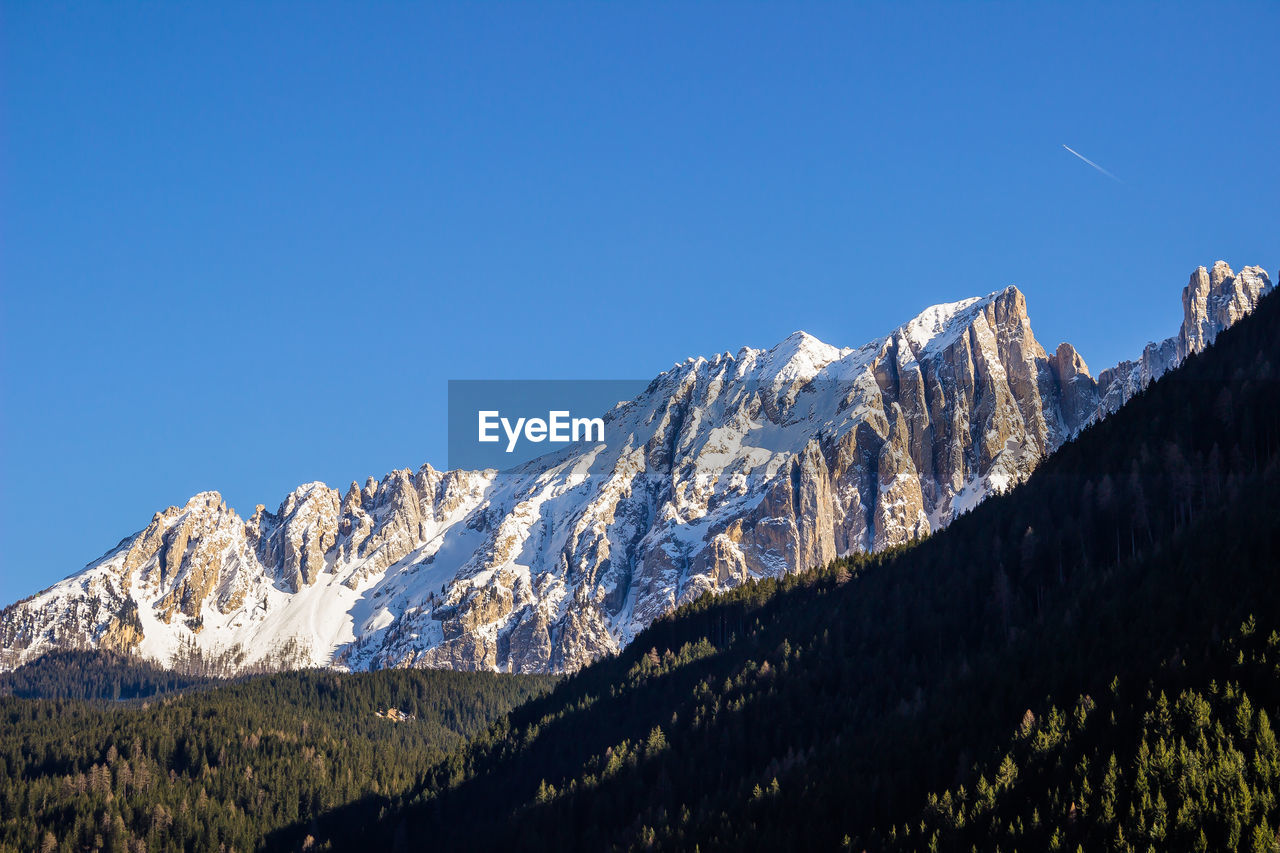 Scenic view of snowcapped mountains against clear blue sky