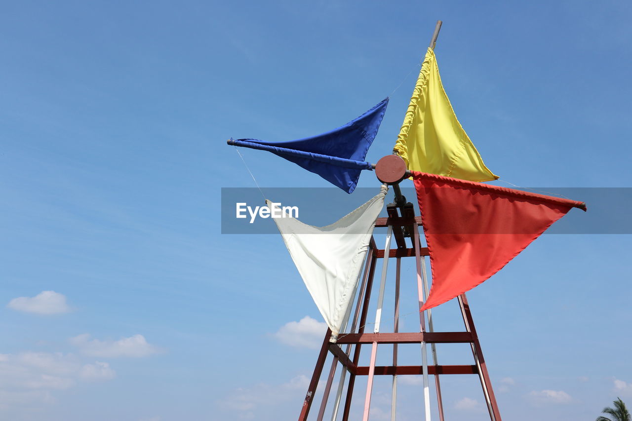 LOW ANGLE VIEW OF FLAGS AGAINST BLUE SKY